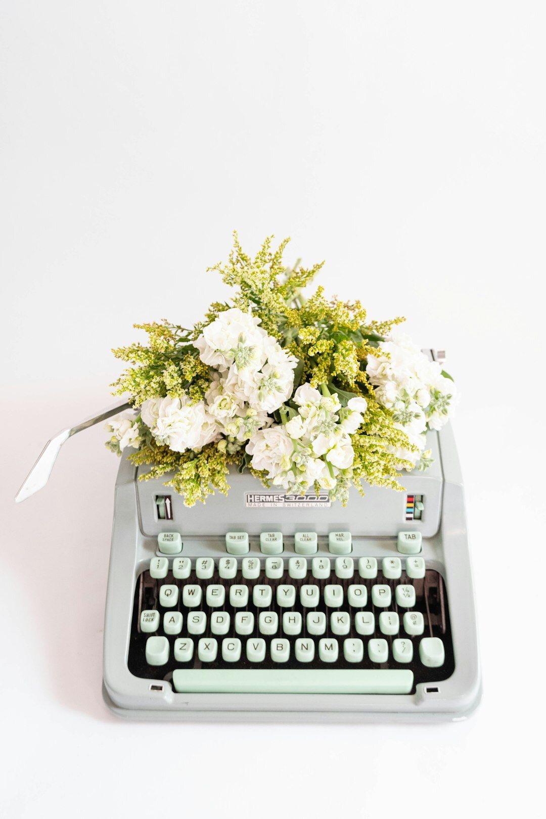 Vintage typewriter on a wooden desk with coffee and a leather notebook